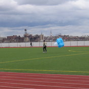 Some strange guy running with a parachute.