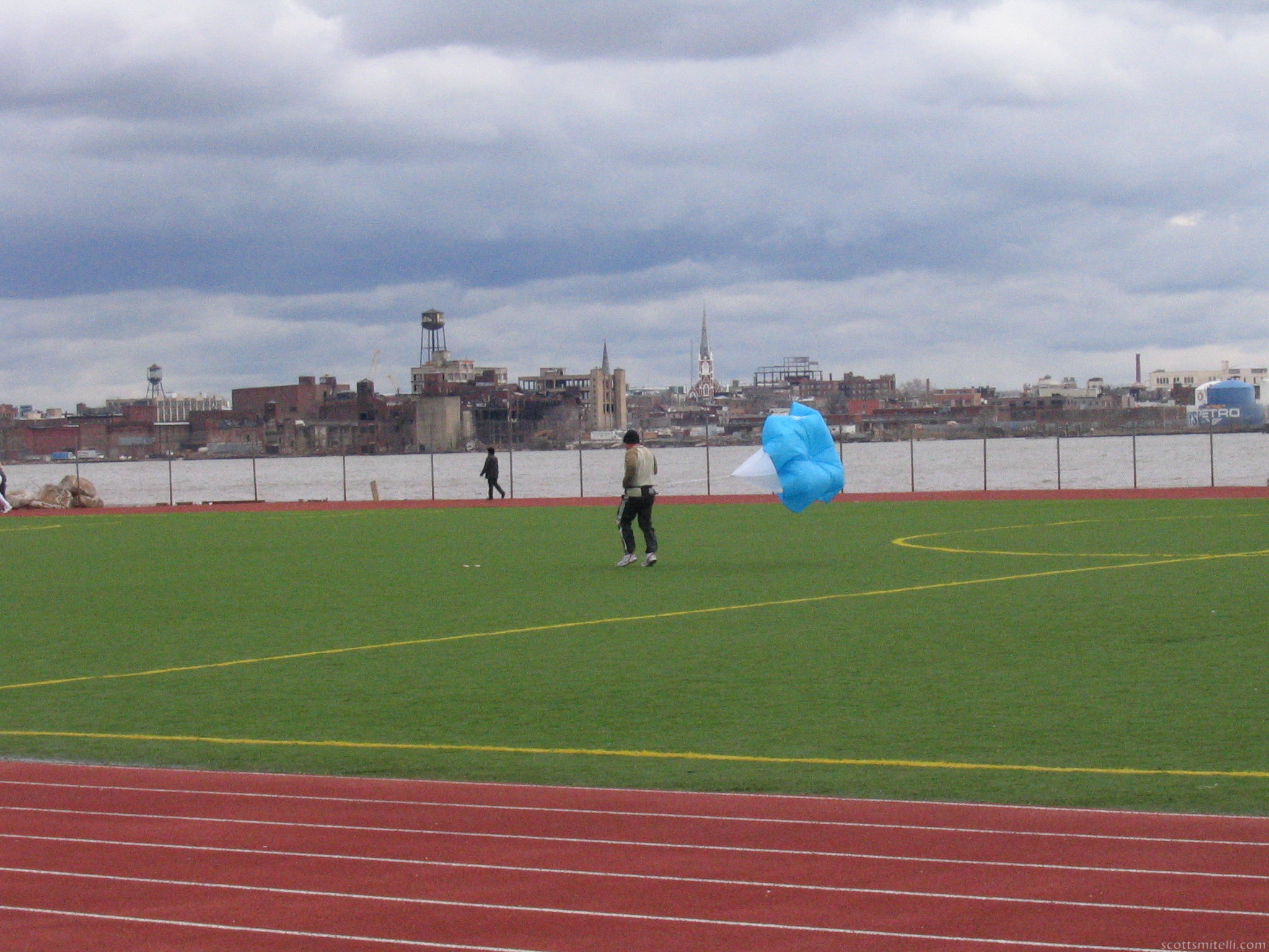 Some strange guy running with a parachute.